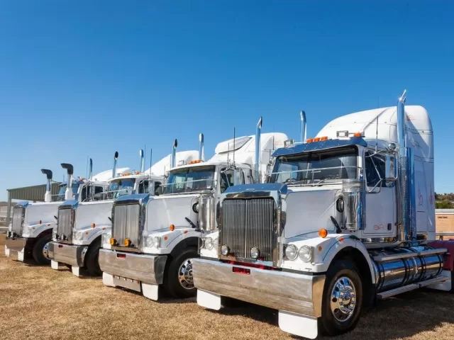 A lineup of powerful prime mover trucks on a highway, symbolizing the best choices for 2024 in Australia's trucking industry.