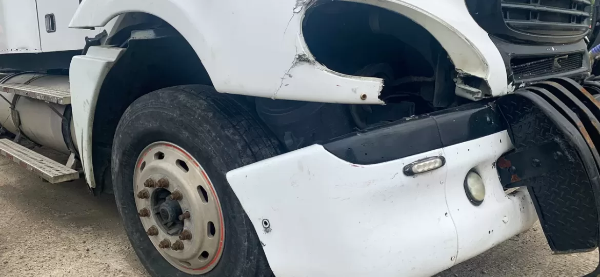 Image of a damaged truck with dented hood and broken headlights, illustrating the need for understanding excesses and deductibles in truck insurance.