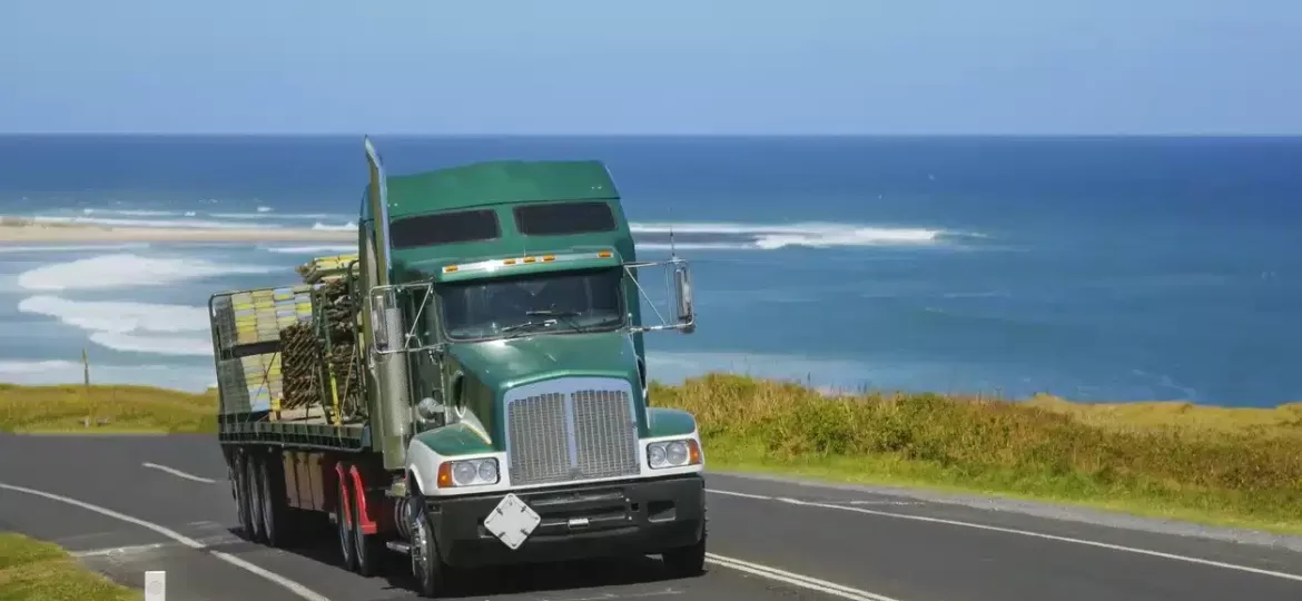 A truck driving along the Australian coastline with the ocean in the background.