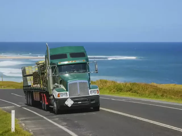 A truck driving along the Australian coastline with the ocean in the background.